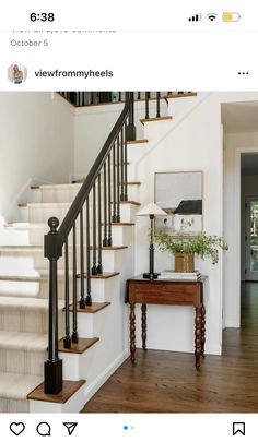 the stairs in this house are white with black railings and wood treading on them