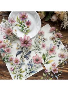 three placemats with flowers on them sitting next to a plate and flower bouquet