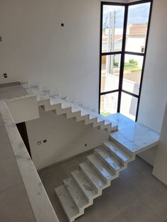 an empty room with stairs leading up to the second floor and a large open window