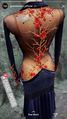 the back of a woman's dress with red flowers on it and gold beads