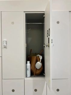 two white lockers with brown purses in them and numbers on the wall behind them