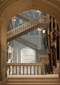 an arch leading into a building with stairs and arches in the center, as seen from below