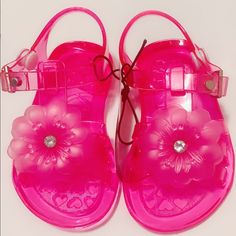 Toddlers Fuchsia, Transparent Jelly Sandals With Flower Embellishment. Pink Plastic Jelly Sandals For Party, Pink Open Toe Plastic Sandals, Playful Plastic Sandals For Spring, Pink Plastic Party Sandals, Pink Plastic Jelly Sandals For The Beach, Spring Non-slip Jelly Sandals, Pink Closed Toe Plastic Sandals, Pink Round Toe Plastic Sandals, Adjustable Pink Jelly Sandals For Beach