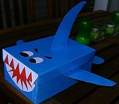 a blue box with a shark face on it sitting on a wooden table next to bottles