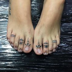 two feet with small tattoos on them