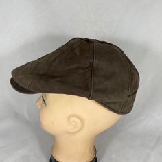 a mannequin's head wearing a brown hat on top of a white background