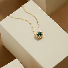 Green is a color that represents rebirth, good fortune, and youth. You can express your feelings or let the right vibe in with this green birthstone necklace. 14k solid gold handcrafted pieces 100% ethical sourced jewelry Material: 14k Solid Gold Diamond Quality:Carat Weight: 0.03 ctwColor: F-GClarity: VS2Cut: Excellent Emerald carat: 0.3 ctw Pendant Height: 6 mm / 0.23 inch Pendant Width: 6 mm / 0.23 inch Chain Style: Cable Chain Chain Length: 18 inch Necklace Ruby, Halo Necklace, Ruby Pendant, Enamel Necklaces, Ruby Necklace, Gold Diamond Necklace, Emerald Necklace, Gold Halo, Unique Diamonds