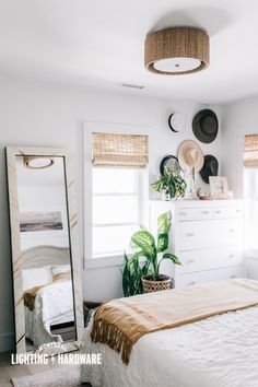 a bedroom with a bed, mirror and plants on the wall in front of it