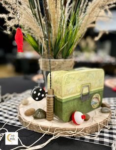 a table with a black and white checkered table cloth, potted plants and decorations