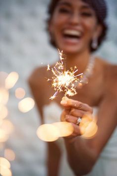 a woman holding a sparkler in her hand