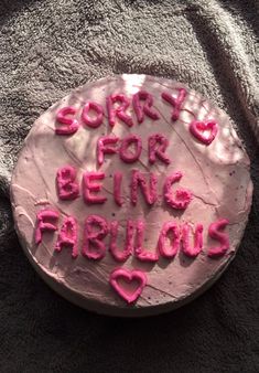 a pink cake with writing on it that says sorry for being fabulous in pink frosting