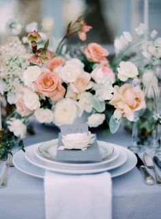 the table is set with white and pink flowers