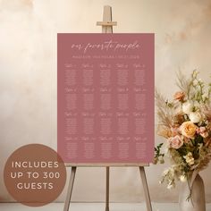 an easel with a pink wedding seating chart on it next to a vase filled with flowers