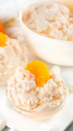 a bowl filled with orange fluff and topped with an orange slice