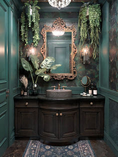 a fancy bathroom with green walls and wooden cabinets, an ornate mirror above the sink