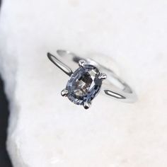 an engagement ring with a blue diamond in the center on top of a white rock