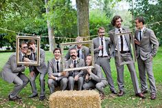 a group of men standing next to each other in front of a hay bale