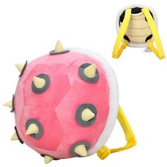 a pink and yellow stuffed animal with spikes on it's back, sitting next to a