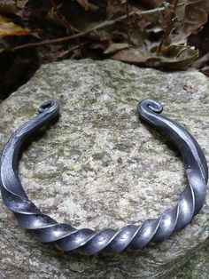 This steel torc bracelet is inspired by the torcs worn by Celtic peoples in antiquity and the oath rings/ arm rings which were popular in Norse cultures. Made from 1/4 inch square mild steel bar, it features eye catching twists and scrolls.  Since these are handmade items, expect slight variations as no two will be exactly alike. Comes in three sizes. Small: for small wrists around 6 inches. Medium: for 6 1/2 to 7 inch wrist sizes. Large: for large wrists 7 1/2 to 7 3/4 inches. Torc Bracelet, Arm Rings, Celtic Viking, Steel Bar, Hand Forged, Arm Band, Halloween Shopping, Vikings, Bangle Bracelets