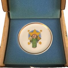 a small plate with an image of the virgin mary on it in a blue box