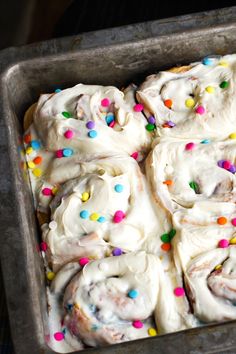 a pan filled with frosted doughnuts and sprinkles on top