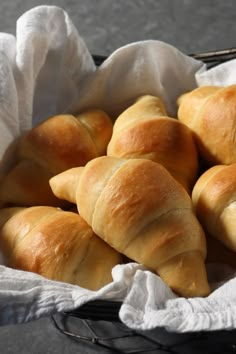 a basket filled with croissants sitting on top of a table