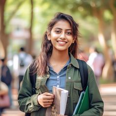 a young woman is smiling and holding her book in one hand while walking down the street