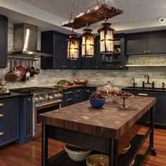 a large kitchen with blue cabinets and wooden counter tops, along with an island in the middle