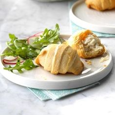 two white plates with food on them sitting on a table next to another plate filled with vegetables