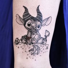 a tattoo on the leg of a person with a small animal and skull in it