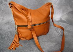 Orange crossbody with ziper and adjustable leather strap and front pocket. Fully lined interior with 2 slip pockets and one zip pocket: Back exterior has a zip pocket. The front also has a zipped pocket. Dimensions: height: 24 cm (9.5 inch) width: 26 cm (10 inch) long strap: max 120 cm (47 inch) Small leather fringe bag, that is made with a pebbled leather.BROWN - https://www.etsy.com/listing/1050765479/crossbody-purse-bag-with-zipper-and?ref=shop_home_active_5&frs=1 ORANGE - https://www.ets Brown Crossbody Saddle Bag With Zipper, Daily Use Crossbody Saddle Bag With Zipper, Crossbody Saddle Bag With Zipper For Daily Use, Zipper Closure Crossbody Saddle Bag, Fall Crossbody Bags With Zipper Pocket, Brown Crossbody Hobo Bag With Zipper Pocket, Tan Leather Handbags, Small Leather Purse, Leather Fringe Bag