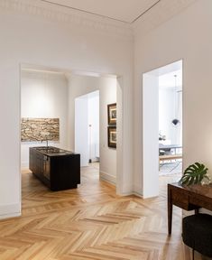 an empty room with wood flooring and white walls in the center is a dining area