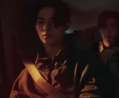 two people are sitting in the back seat of a car and one person is looking off into the distance