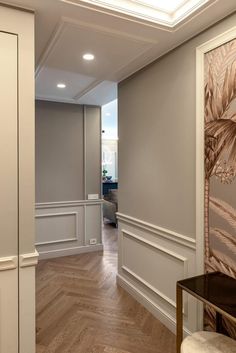 an empty room with wood floors and white walls, along with a painting on the wall