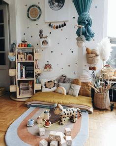 a child's room with toys and decor on the wall, including a toy giraffe