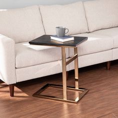 a white couch sitting next to a coffee table on top of a hard wood floor