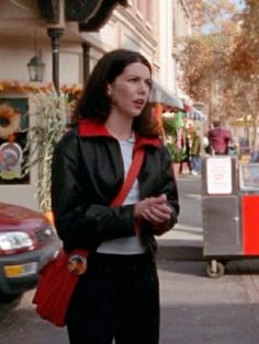 a woman is standing on the street talking to someone