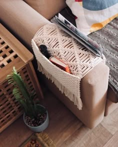 a couch with a plant on top of it and a magazine rack next to it