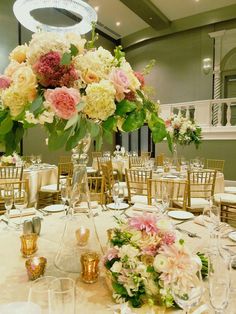 the centerpieces on this table are filled with pink and white flowers