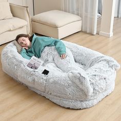 a woman is laying on a large bean bag chair in the middle of a living room