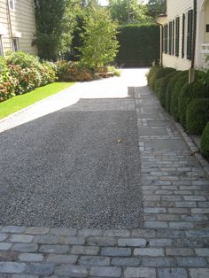 the driveway is lined with cobblestones and grass