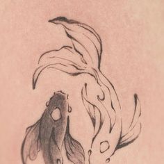 a black and white drawing of a fish on the back of a woman's shoulder