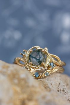 a gold ring with blue topazte and green tourmaline in the center