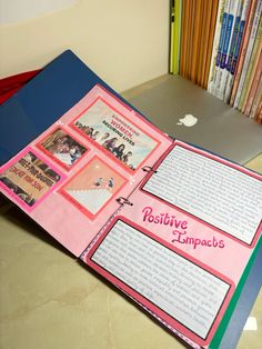 an open book with pictures on it sitting on a table in front of bookshelves