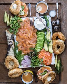 an assortment of food is laid out on a wooden table with utensils and sauces