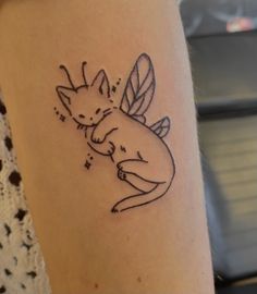 a small tattoo on the arm of a woman with a cat in it's lap