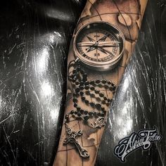 a man's arm with a compass and rosary on it