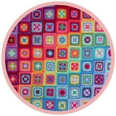 a colorful crochet pattern in a circle with pink border around the center and bottom