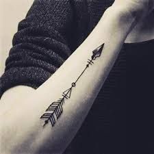 a woman's arm with an arrow tattoo on it