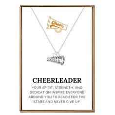 the cheerleader necklace is displayed in a wooden frame with an inspirational quote on it